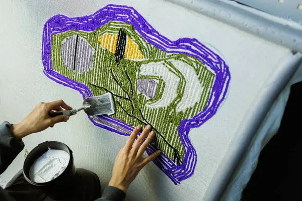 El yapımı halı ipliklerini yapıştırıcı ile onaran bir kadın parçası.