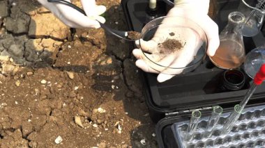 asian scientist analyzing an water and soil to find solutions of soil deterioration problems.