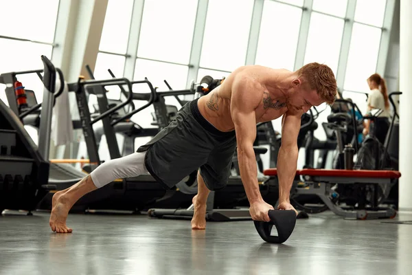 Muscular man doing push up in the gym. Athletic man doing exercise with push up. Man workout push up in the gym. Sport fitness and healthy lifestyle