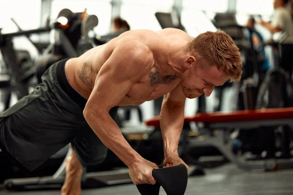 Muscular man doing push up in the gym. Athletic man doing exercise with push up. Man workout push up in the gym. Sport fitness and healthy lifestyle