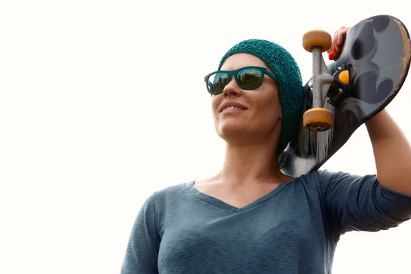 一个微笑的成年女子滑板手拿着滑板的画像 在滑板公园里拿着滑板的女人看着外面的摄像头 — 图库照片