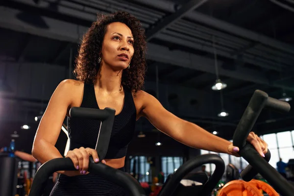 african american woman cardio slimming aerobics training on bicycle.