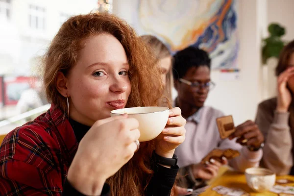 Międzynarodowa Firma Młodych Ludzi Pije Kawę Gra Gry Patrzy Smartfony — Zdjęcie stockowe
