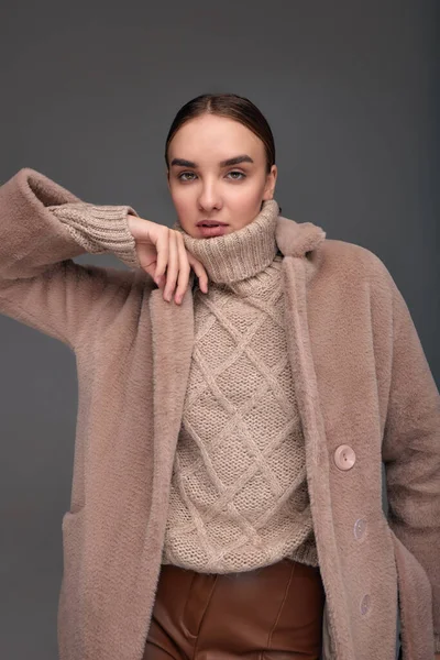 ファッション若いです女性でフェイクファーコート上の灰色の背景 — ストック写真