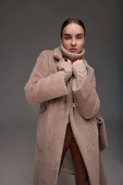 ファッション若いです女性でフェイクファーコート上の灰色の背景 — ストック写真