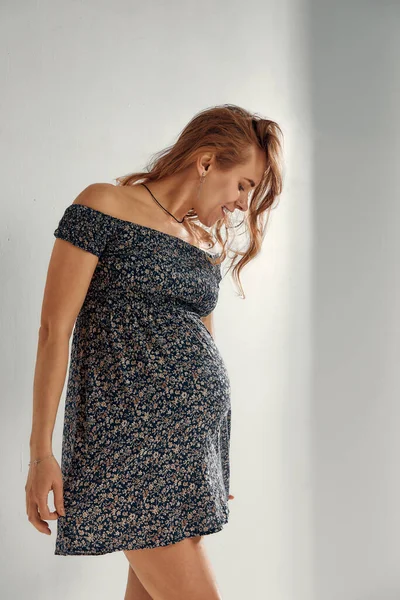 スタジオポートレートの明るい若いです妊娠中の女性で夏のドレス上の白い灰色の背景 幸せな妊娠の概念 — ストック写真