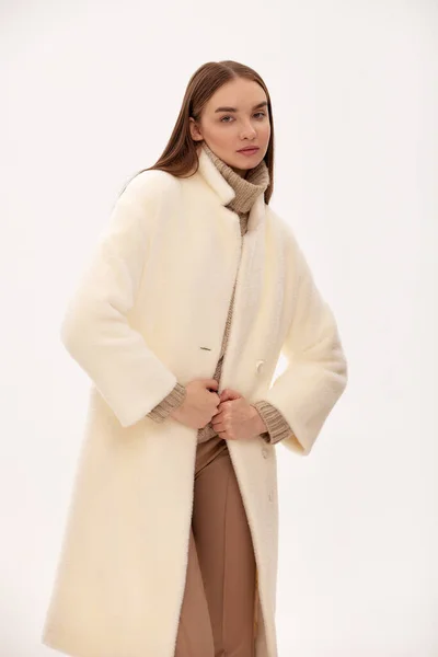 ライトフェイクファーのコートに身を包んだ ファッショナブルな自信に満ちた女の子 フェイクファーで作られた毛皮のコートのための現代的なファッショントレンド 薄手の背景に毛皮のコートを着たモデル — ストック写真