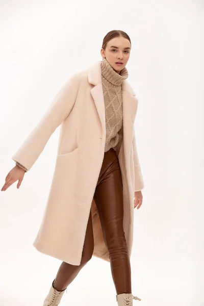 ライトフェイクファーのコートに身を包んだ ファッショナブルな自信に満ちた女の子 フェイクファーで作られた毛皮のコートのための現代的なファッショントレンド 薄手の背景に毛皮のコートを着たモデル — ストック写真