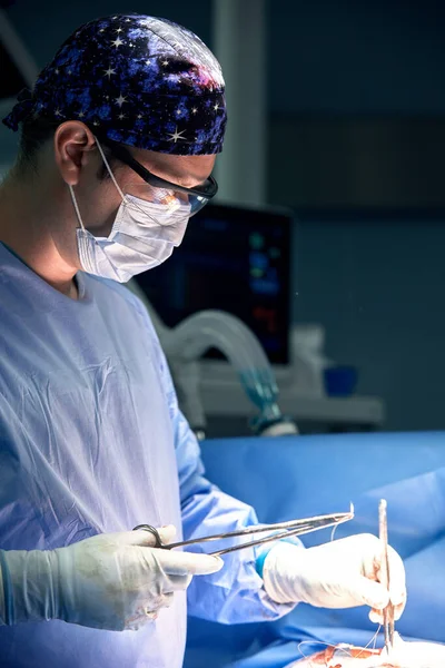 Чоловічий Хірург Виконує Операцію Темній Операційній Кімнаті Лампою Задньому Плані — стокове фото