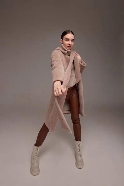 光の背景に毛皮のコートを着た美しいビジネス女性 市場のための写真 製品のデモンストレーション 人工毛皮 人工毛皮で作られた毛皮のコートに身を包んだ女の子 — ストック写真