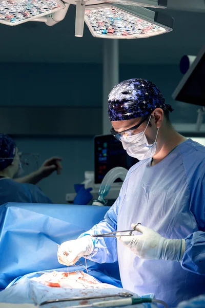 手术室里一名男性外科医生的画像 背景是现代外科和照明设备 一个现代手术室 一名医生的刻苦工作 — 图库照片