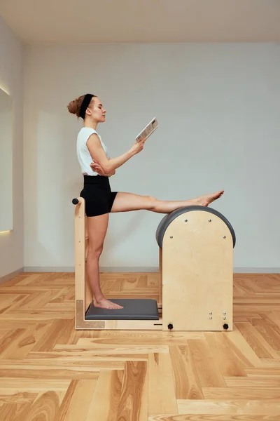 Uma Menina Está Envolvida Pilates Sobre Reformador Livro Aulas Pilates — Fotografia de Stock