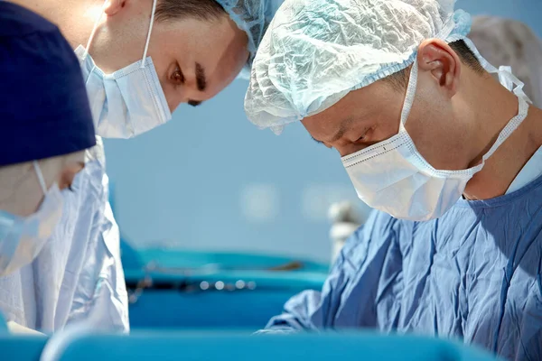在复杂而紧张的手术中 面对外科医生的特写 医生挽救了病人的生命 外科医生的协同工作 — 图库照片