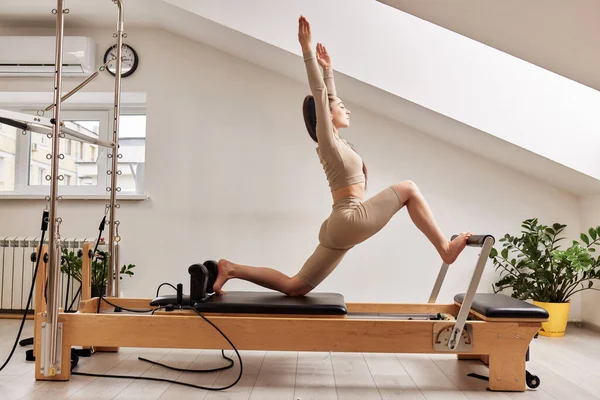 Seorang Gadis Muda Melakukan Pilates Tempat Tidur Reformis Studio Cerah Stok Gambar