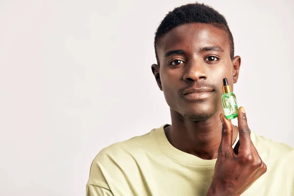 Africano Con Una Maglietta Con Una Bottiglietta Verde Crema Pelle — Foto Stock