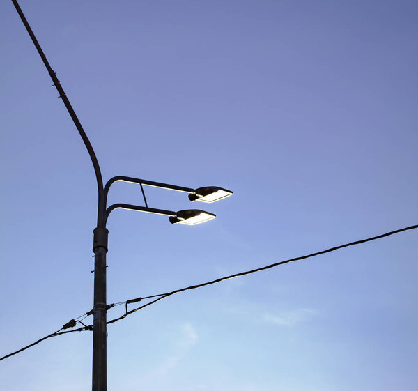 Уличные фонари на голубом фоне неба.