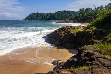 Rocks, waves, sand and vegetation at Praia do Resende beach, Itacare, Bahia, Brazil