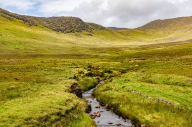 Dromalonhurt 'deki küçük nehir, dağlar ve tarlalar, Kerry, İrlanda