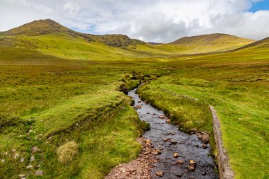 Dromalonhurt 'deki küçük nehir, dağlar ve tarlalar, Kerry, İrlanda