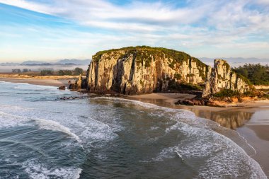 Guarita sahilinde dalgalar, kayalıklar ve ağaçların üzerinde kış sisi, Torres, Rio Grande do Sul, Brezilya