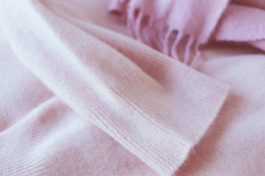 Kaşmir doku, doğal yün, masaya katlanmış pembe kaşmir elbiseler, kumaş arka plan, üst görüş, sıcaklık ve kış konforu kavramı.