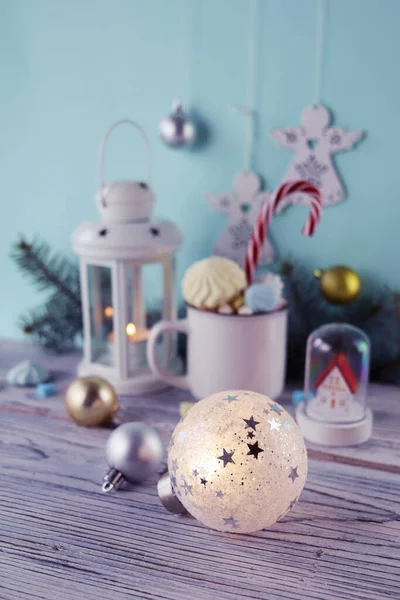 圣诞装饰品 一杯加白葡萄酒和棉花糖的咖啡 一盏点着蜡烛的灯笼 发亮的球和背景上放着冷杉枝条的圣诞玩具 — 图库照片