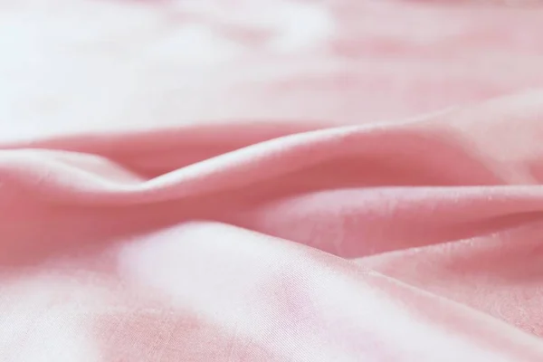 Texture of pink natural silk, folds, top view, background for romantic congratulations, emotion of love