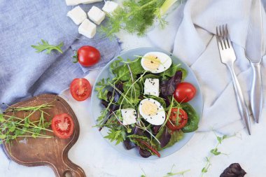 Mikro sebze salatası, marul, domates, peynir ve haşlanmış yumurta, tabakta, masada, doğal malzemelerin tarifi, sağlıklı yiyecekler.
