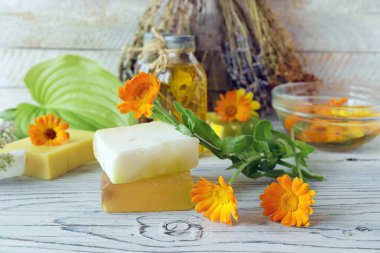 Takvim çiçekleri, sabun, yağlar ve tentürler, ahşap bir arka planda, doğal malzemeler, alternatif tıp