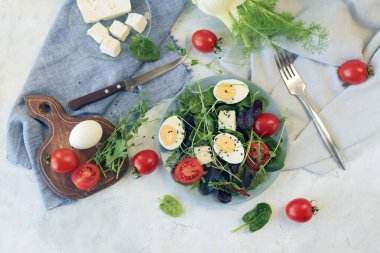 Mikro sebze salatası, marul, domates, peynir ve haşlanmış yumurta tabakta.