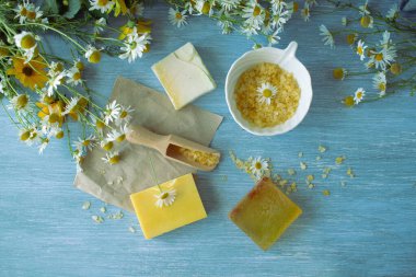 Papatyalı sabun, taze papatya çiçekleri ve deniz tuzu, ahşap arka planda, doğal kozmetik ürünleri, vücut bakımı ve banyo ürünleri.