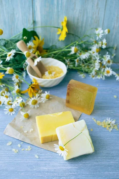 stock image Soap with chamomile, bouquets of fresh chamomile flowers and sea salt, on a wooden background, natural cosmetics, body care and bath products