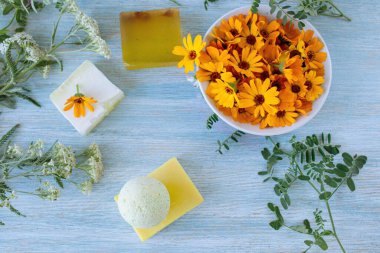 Takvimli sabun, taze çiçekler ve kullanışlı bitkiler, ahşap arka planda, doğal kozmetik ürünleri, vücut bakımı ve banyo ürünleri