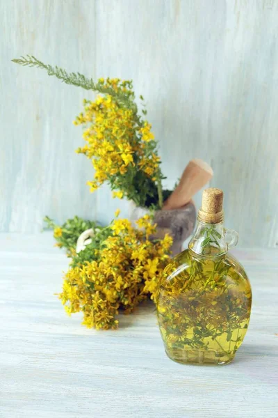 Stock image Bottle of St. John's wort oil, soap and flowers on a wooden background