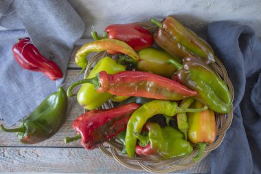 Ahşap zemin üzerinde kırmızı ve yeşil biberler mevsimlik organik sebzeler. 