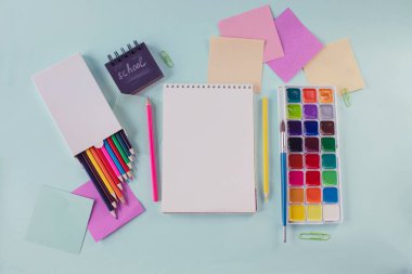 Renkli kalemler, boyalar ve pastel renklerle yazılı kağıtlar, okul konseptine, kırtasiyeye geri dönüş. Düz yatış, üst görünüm.