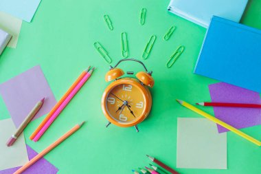 Alarm saati, okul gereçleri ve pastel renklerde yaratıcı öğrenme materyalleri, okula dönüş..