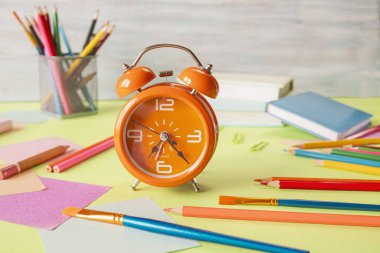Alarm saati, okul gereçleri ve pastel renklerde yaratıcı öğrenme materyalleri, okula dönüş..