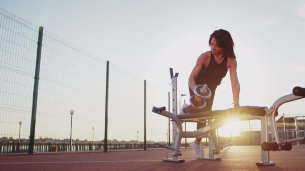 Sportive Woman Lifts Dumbbell Leaning Training Apparatus Installed Sports Ground — 비디오