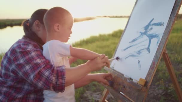 Patient Mother Helps Little Disabled Boy Draw Easel Canvas Paintbrush — 비디오