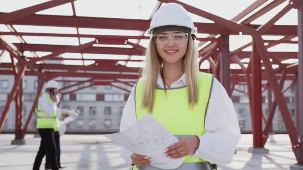 Portrait Young Female Contractor Hardhat Smiling Looking Camera Busy Colleagues — Wideo stockowe
