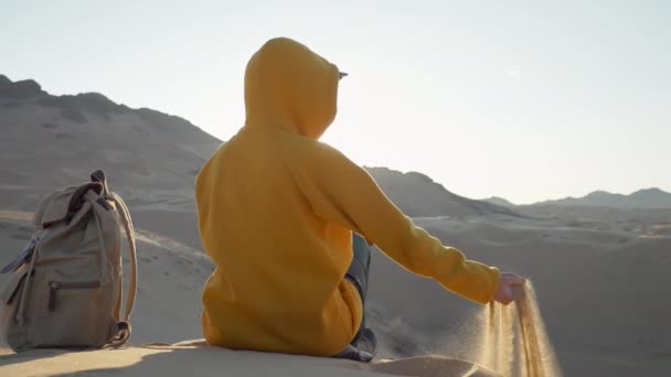 Gezgin Çöl Kumulunda Otururken Eline Kum Döker Gündoğumunda Geriye Bakar Stok Video