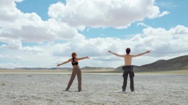 İki genç yürüyüşçü birlikte spor yapıyorlar. Dağların ıssız bölgelerinde duruyorlar. Doğada sağlıklı yaşam tarzı, açık havada dinlenme aktiviteleri.