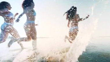 Gün batımında deniz suyuna koşup ellerini kaldıran mayo giymiş birkaç genç ve güzel kadın her yöne doğru sıçrıyor. Eğlence, eğlence, tasasız, tatil köyünde yaz tatili