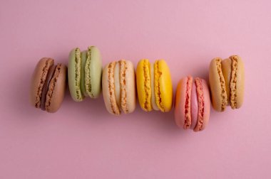 Makarnalar renkli kurabiyeler. Makarna, tatlı tatlı, üst manzara, pembe arka plan.
