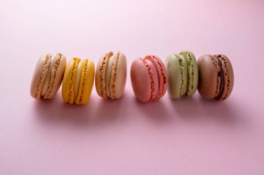 Makarnalar renkli kurabiyeler. Makarna, tatlı tatlı, üst manzara, pembe arka plan.
