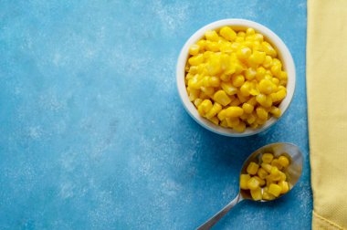 Mavi arka planda bir kase mısır. Boşluğu kopyala.