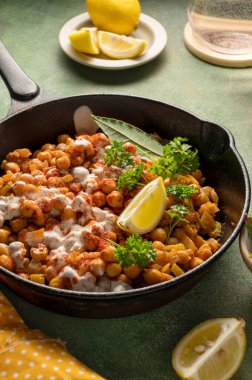 Köri ve baharatlı kızarmış nohut, ev yapımı vejetaryen nohut, sağlıklı yemek, renkli yeşil arka plan..