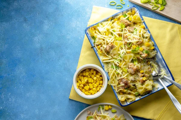 Tuna Pasta Bake with sweet corn. One pan easy, comfort food, blue background, copy space
