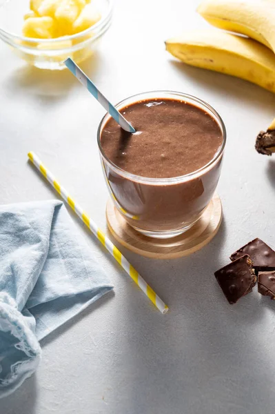 Protein chocolate shake with banana, protein powder and cocoa. Healthy fitness drink, vertical photo